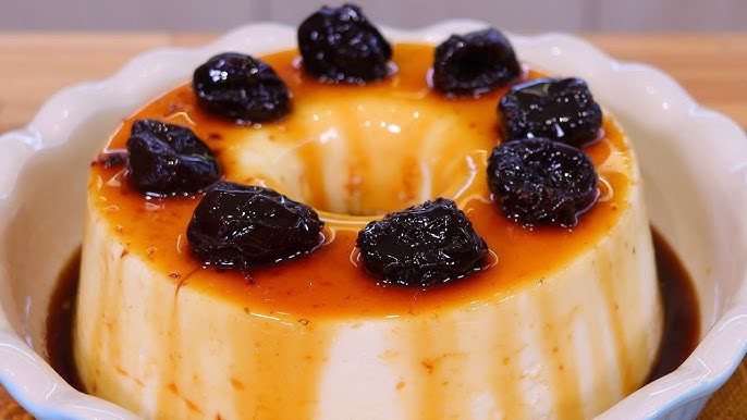 A slice of creamy Coconut Pudding (Manjar de Coco) topped with a glistening amber syrup and decorated with plump prunes.