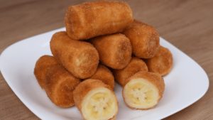 A plate of Bananas Fritas, with a dusting of cinnamon and a drizzle of condensed milk.